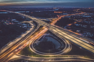 Illuminated road junction at dusk aerial view. Transport industry, toned image.